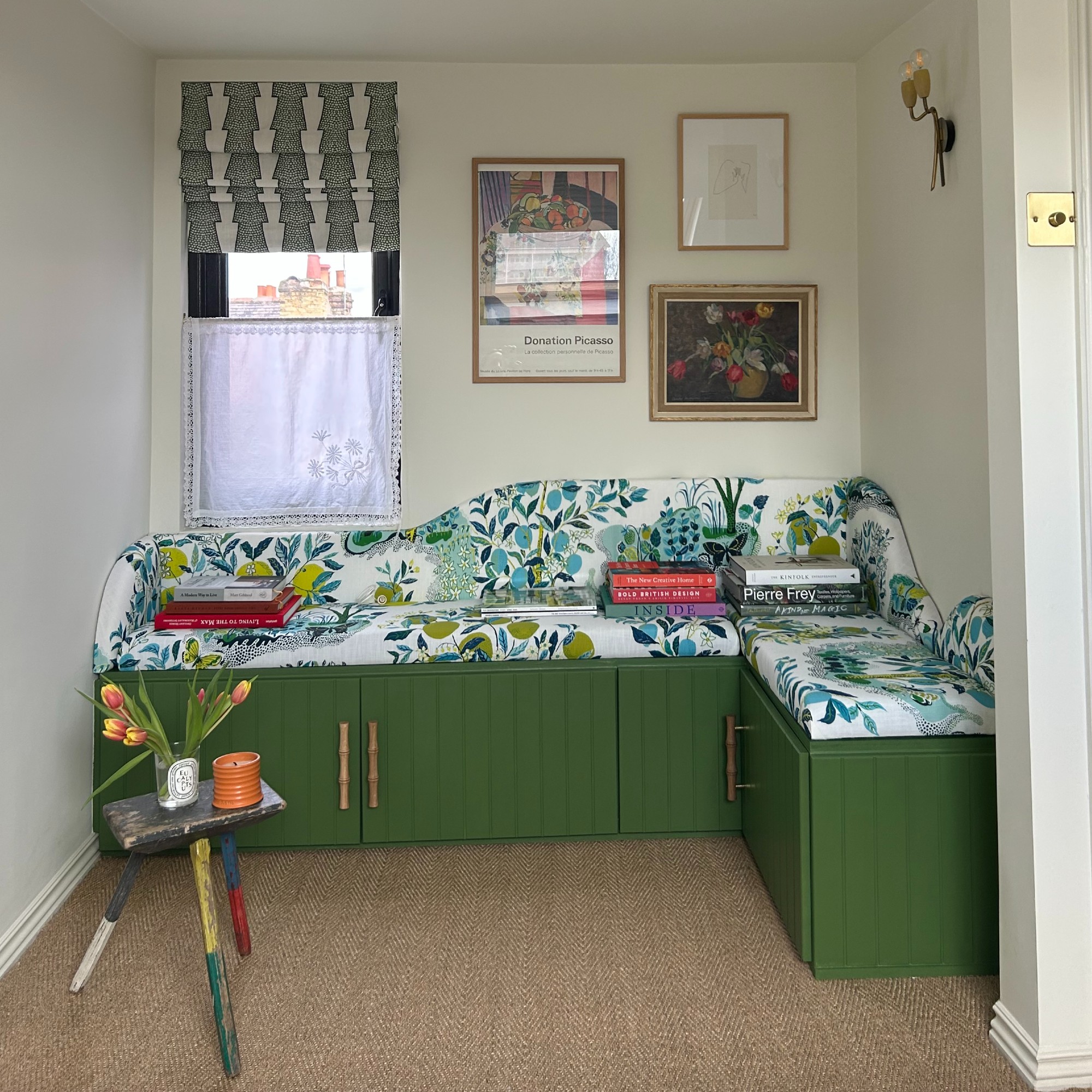 A green corner storage bench made with IKEA BESTA cabinets with a botanical-print seat cushion on top 