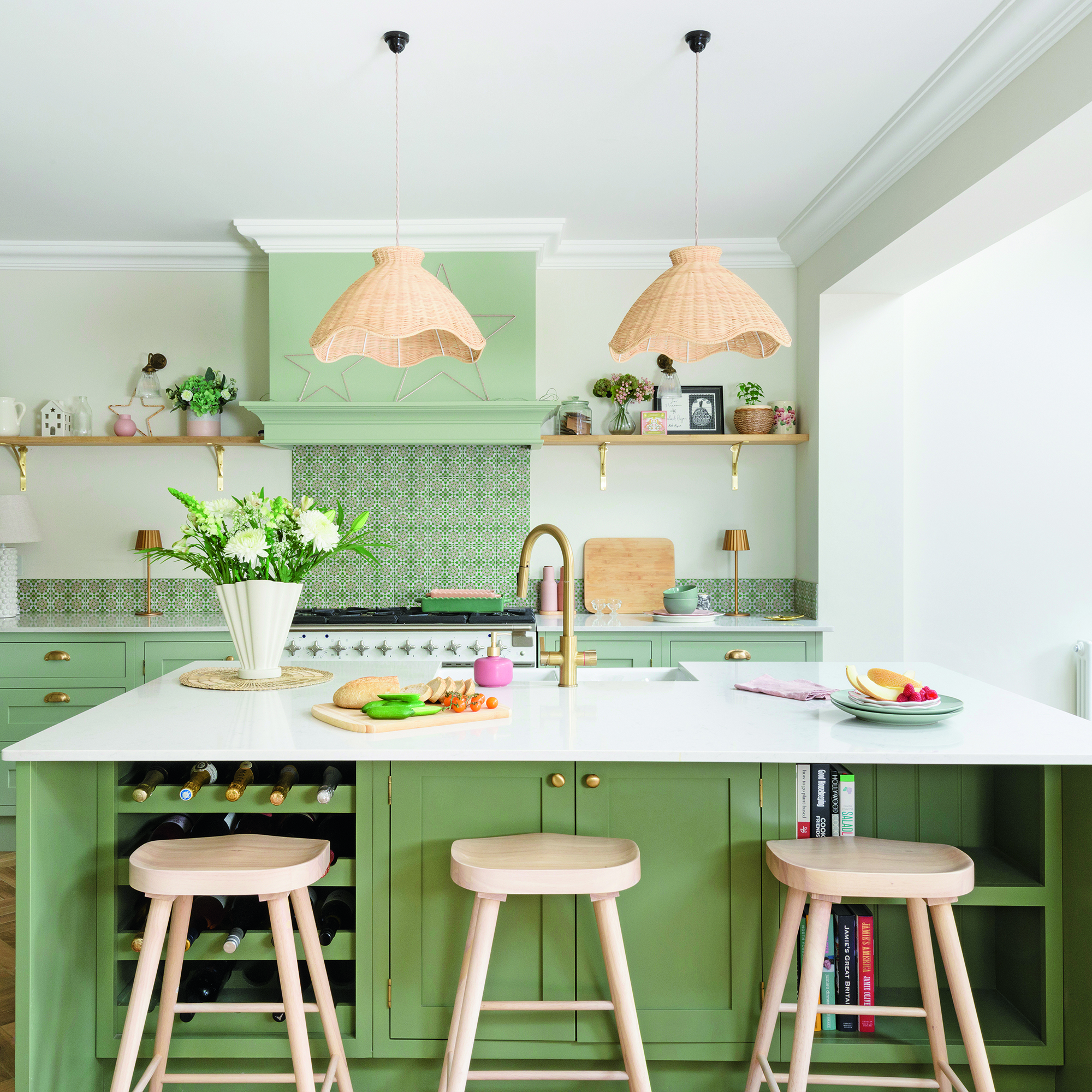 Green kitchen with island and brass tap