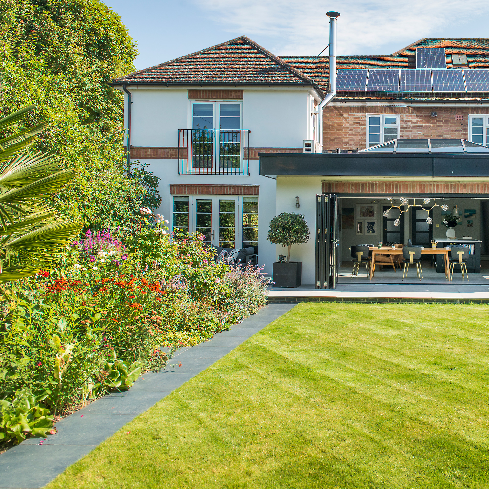a garden with a large, perfectly kept lawn and lots of prairie-style flower planting in the borders
